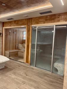 NEO Apartman في زلاتيبور: غرفة مع أبواب زجاجية وغرفة مع حوض استحمام