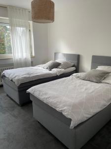2 Einzelbetten in einem Schlafzimmer mit Fenster in der Unterkunft Ideale Unterkunft in Düsseldorf-Nord in Düsseldorf