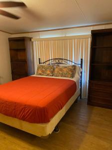 um quarto com uma cama com uma colcha laranja em Edgewater Getaway em Port Lavaca