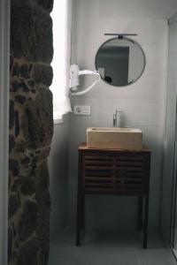 a bathroom with a sink and a mirror at Amodiño do Camiño in Belesar