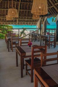 a group of tables and chairs on the beach at Dhow Resort in Jambiani