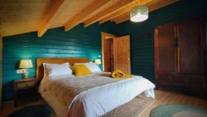1 dormitorio con 1 cama grande y paredes azules en Casa rural El Bujo, en Solana de Ávila