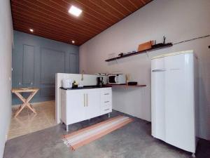 eine Küche mit einem weißen Kühlschrank im Zimmer in der Unterkunft Casa agradável com jacuzzi, área de lazer, enxoval in Andradina