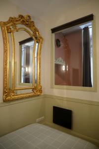 a room with a mirror and a tv on a wall at Le Stanislas, un style! in Nancy