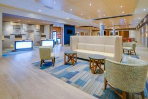 a lobby with a waiting room with tables and chairs at Holiday Inn Express & Suites Ft. Washington - Philadelphia, an IHG Hotel in Fort Washington