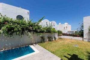 a backyard with a swimming pool and a house at Duplex avec piscine Détente et élégance in Gammarth