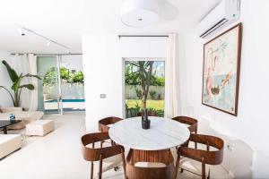 una sala de estar blanca con mesa y sillas en Duplex avec piscine Détente et élégance, en Gammarth