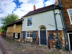 an old brick house with a blue door on a street at Chapter House YORK in York