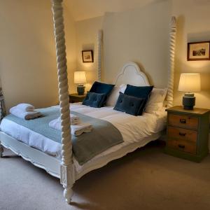 a bedroom with a four poster bed with blue pillows at Chapter House YORK in York +51 photos