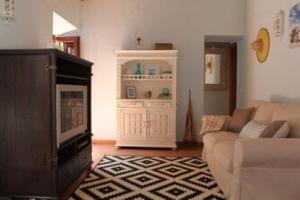 a living room with a couch and a cabinet at Casa de Seixe in Odeceixe