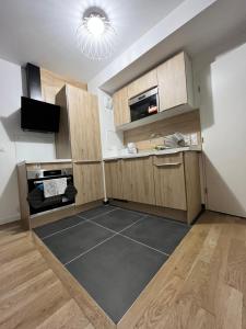 kuchnia z drewnianymi szafkami i czarną podłogą w obiekcie Superbe appartement de 51m2 à 10mn de Paris w mieście Boulogne-Billancourt