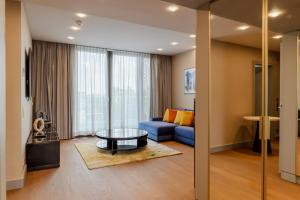 a living room with a blue couch and a table at Fourty Three Luxury Serviced Apartments in Düsseldorf