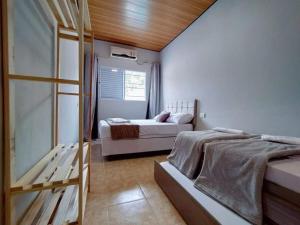 1 Schlafzimmer mit 2 Betten und einem Fenster in der Unterkunft Casa agradável com jacuzzi, área de lazer, enxoval in Andradina