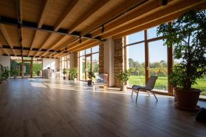 una camera spaziosa con pavimento in legno e finestre di Agriturismo Ponte Florio a Verona