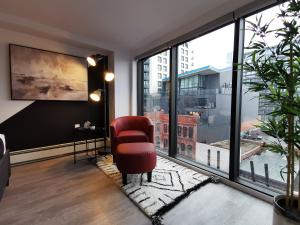 a living room with a red chair and a large window at Cameo Hotel and Suites in Halifax