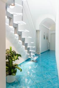 アマルフィにあるAmalfi Ammorèの青の床と白い階段が備わる客室です。