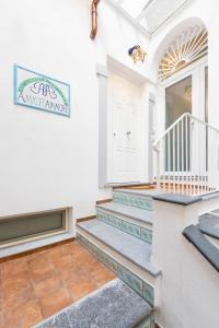 une maison blanche avec des escaliers et un panneau sur le mur dans l'établissement Amalfi Ammorè, à Amalfi