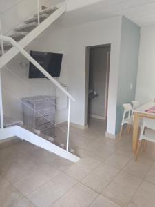 sala de estar con escalera, TV y mesa en Aires de Ambar en Merlo