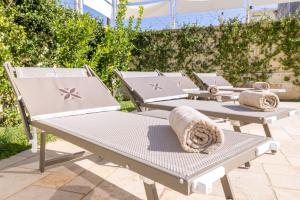 - une rangée de chaises longues sur la terrasse dans l'établissement Il Casale Normanno, à San Vito dei Normanni