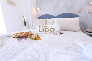 ミザーノ・アドリアーティコにあるHotel Lidoのベッド(ホテルのリド枕、花付)
