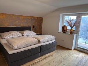 sypialnia z dużym łóżkiem i dużym oknem w obiekcie Ferienwohnung Krallinger w mieście Wenns