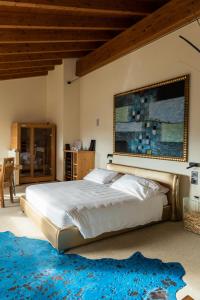 ein Schlafzimmer mit einem großen Bett und einem blauen Teppich in der Unterkunft Locanda Sensi in Rivergaro