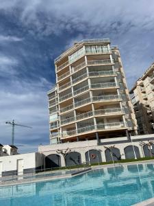un edificio alto con piscina frente a un edificio en Alpen1 Argenta/Caleta, en Peñíscola