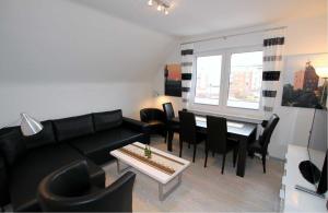 uma sala de estar com um sofá preto e uma mesa em Neuwerk em Cuxhaven