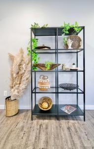 a black book shelf with plants and other items at Downtown Boho Revival Home PNW in Albany