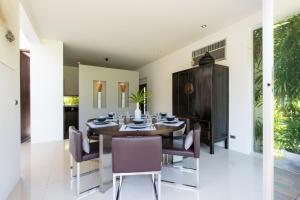 Un comedor con mesa y sillas en Villa Koru Samui, en Mae Nam