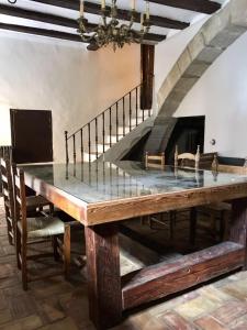 a dining room with a table and a staircase at La Casa Amarilla in Rubielos de Mora