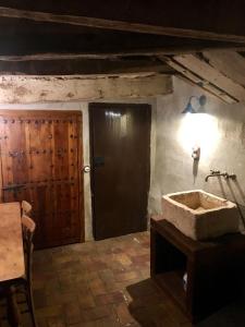 ein Badezimmer mit einem Steinwaschbecken und einer Holztür in der Unterkunft La Casa Amarilla in Rubielos de Mora