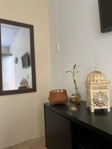 - une table avec un miroir et un vase dans l'établissement Coco Suites, à Abraão