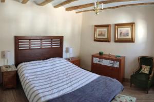 a bedroom with a large bed and a chair at La calma de Arnedillo in Arnedillo