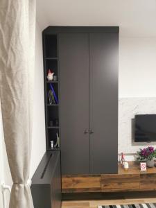 a large gray cabinet in a living room at Nacional 3 apartman studio in Subotica