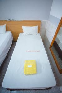 a white bed with a yellow object on it at Hotel Brothers São Paulo - 3km do Hospital das Clínicas FMUSP, proximo a Universidades - By UP Hotel in Sao Paulo