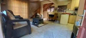 a living room with a couch and a kitchen at The Court House- Ramsgate KZN in Ramsgate