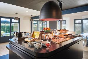 a kitchen with a buffet of food on a counter at Kyriad Brie-Comte-Robert in Brie-Comte-Robert