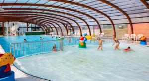 MOBILHOME CLIMATISE TOUT CONFORT 6 à 8 PERSONNES à louer في Litteau: مجموعة من الناس يلعبون في حمام السباحة