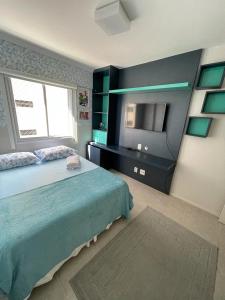 um quarto com uma cama e uma televisão em Apartamento Confortável e Completo - JTR em Maceió