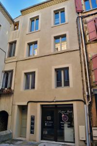 un edificio bronceado con ventanas y puertas en una calle en L'atelier, en Crest