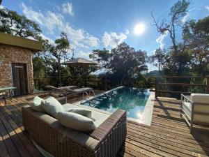 坎普斯杜若爾當的住宿－奧拓達博阿維斯塔旅館，一个带沙发和桌子的甲板上的游泳池