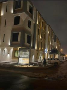 شقة فاخرة تحتوي على غرفتي نوم و مدخل خاص جانبي في الرياض: مبنى فيه سيارة متوقفة أمامه في الليل