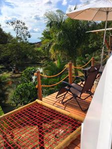 una terraza con una silla y una sombrilla en Glamping Sant Sebastian en Tuluá