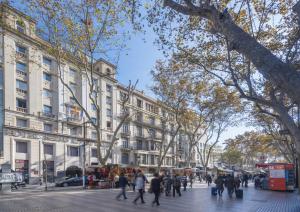 a group of people walking down a city street at Hotel SERHS Rivoli Rambla in Barcelona