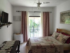 a bedroom with a bed and a large window at Pousada Bem Querer in Penedo