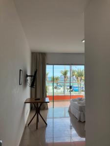 a bedroom with a bed and a view of the ocean at HOTEL ENSEADA BEIRA MAR in Guarujá