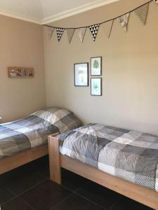 2 Betten in einem Schlafzimmer mit Fahnen an der Wand in der Unterkunft Logies De Hooiberg in Lutjewinkel