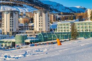 une ville dans la neige avec des bâtiments dans l'établissement Attico Villaggio Olimpico Sestriere, à Sestrières