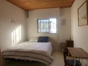 Habitación pequeña con cama y ventana en VILLA LES HORTENSIAS - proche de la plage, en Jard-sur-Mer